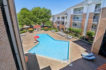 Serene swimming pool with lounge seating, patio tables, and umbrellas